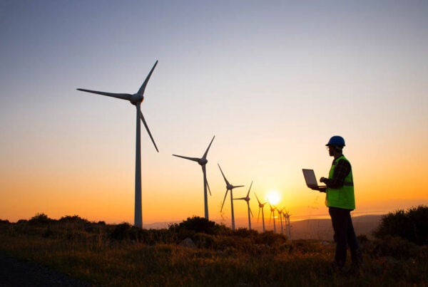 Man working in a field with wind turbines
